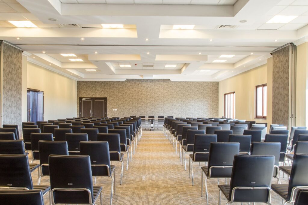 Sala preparada para un evento corporativo, con las sillas en filas y el pasillo central